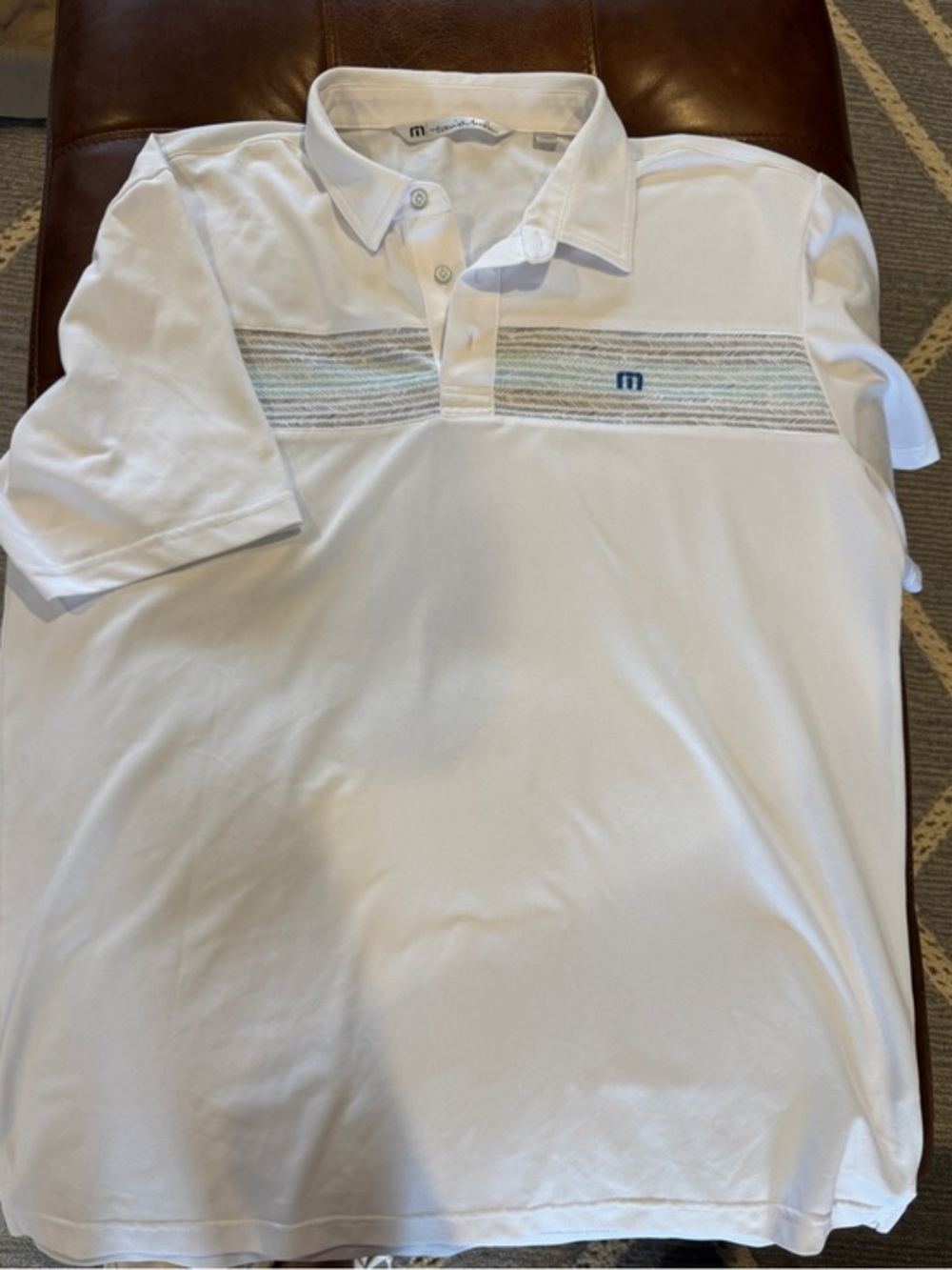 Travis Mathew White Polo with Subtle Blue and Tan Stripe Chest
